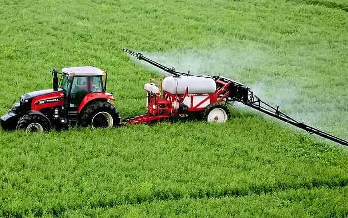 Трактор вносить оприскувачем добрива